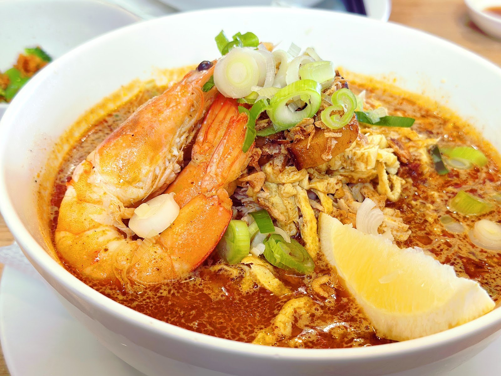 Curry laksa with prawns, bean sprouts, spring onion and a wedge of lemon