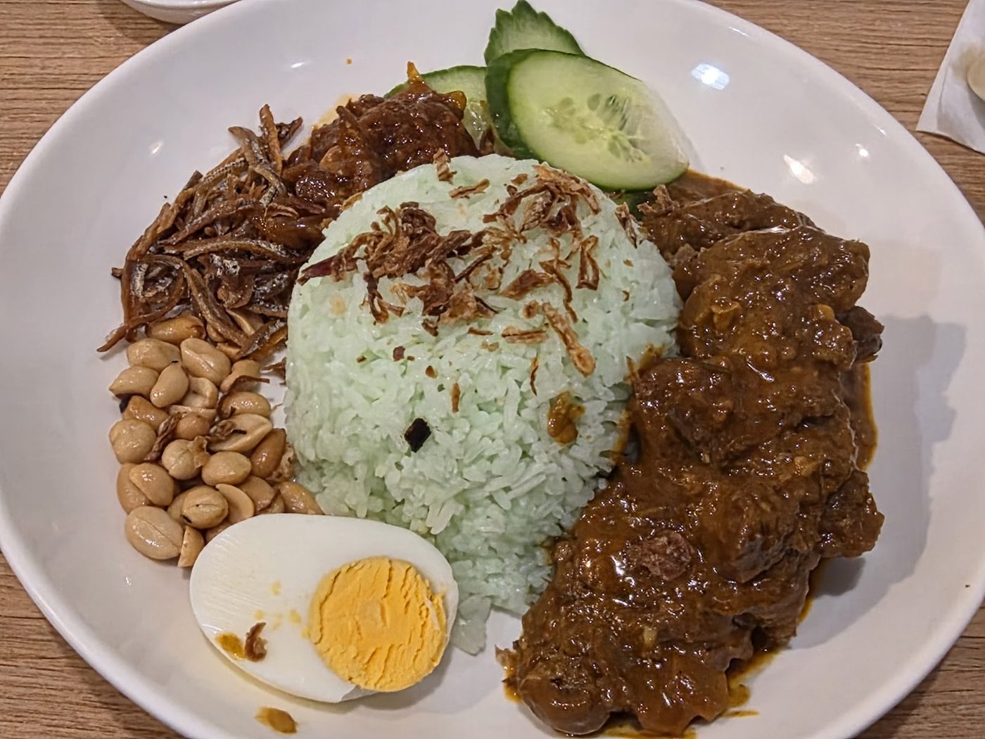 Nasi lemak: coconut rice with rendang beef, boiled egg, peanuts and cucumber